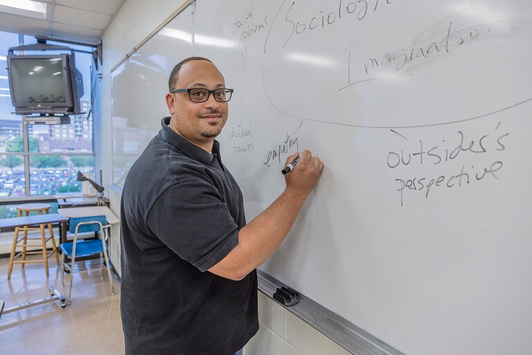 professor writing on whiteboard