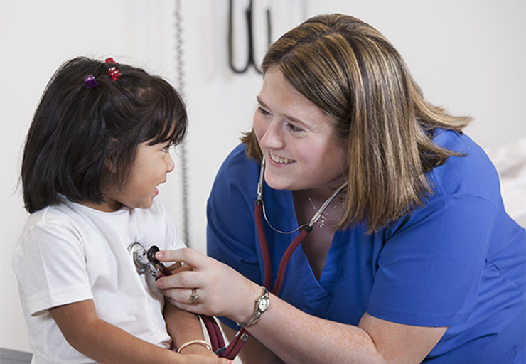 nurse smiling while helping a child