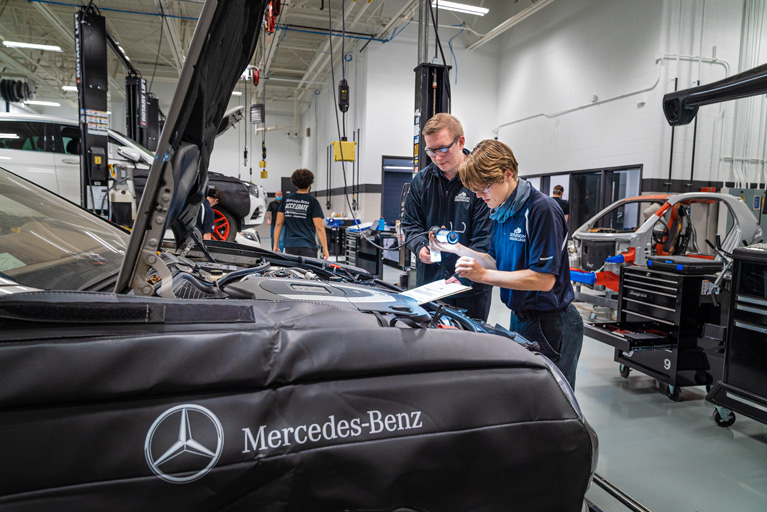 two students working on a Mercedes-Benz
