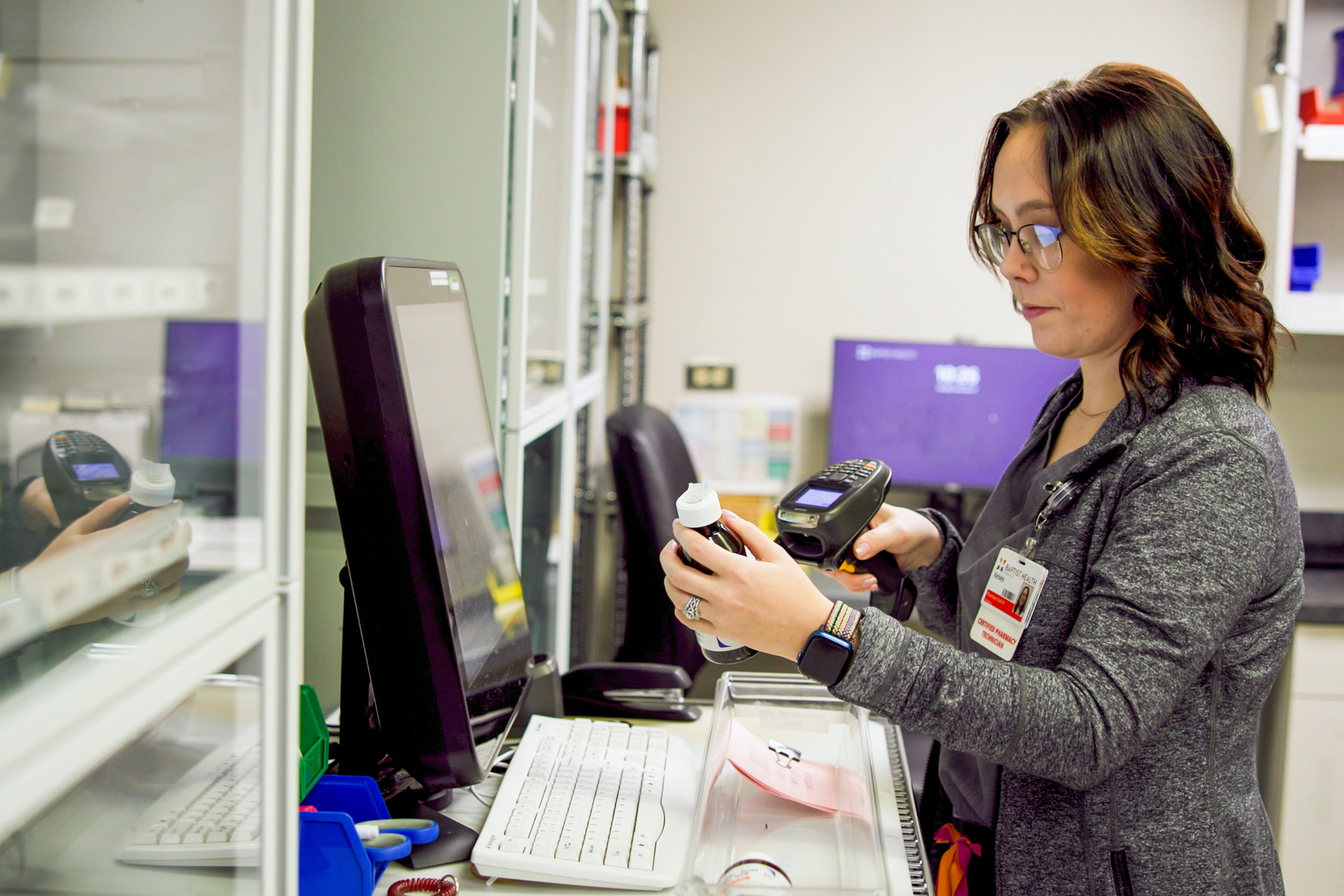 female Pharmacy Technician scanning a bottle in a pharmacy